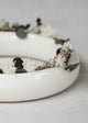 Floral wreath on a white ceramic vase against a light background